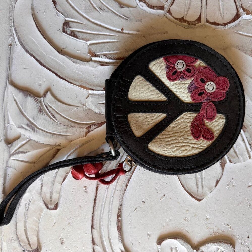 Lucky Brand zip-around wallet features a peace sign design with floral accents